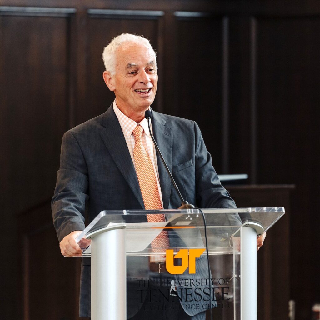 Chancellor Peter Buckley speaking joyfully at a podium